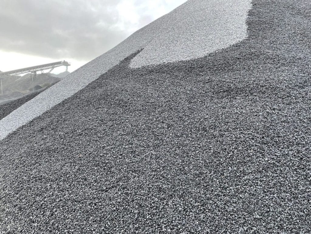 Large gravel mound with conveyor in the cloudy background.