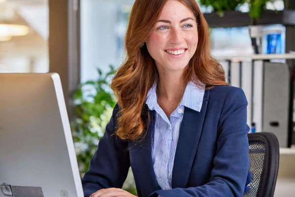 Cheerful administration assistant working at a computer