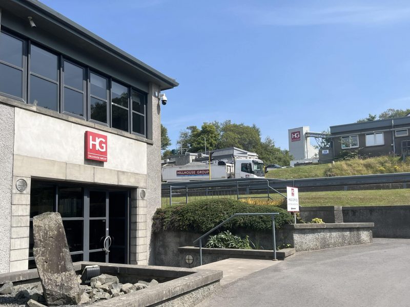 Commercial building and lorry with HG Hillhouse Group branding on a sunny day.