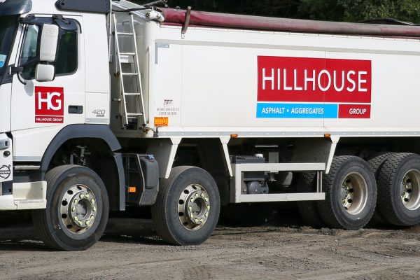 Large white industrial truck with multiple wheels, displaying Hillhouse Group asphalt branding.