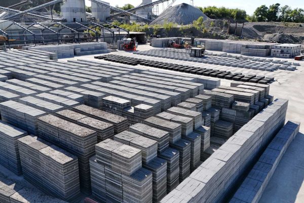 Concrete Block Storage Area Large outdoor area with stacked concrete blocks and industrial equipment in the background.